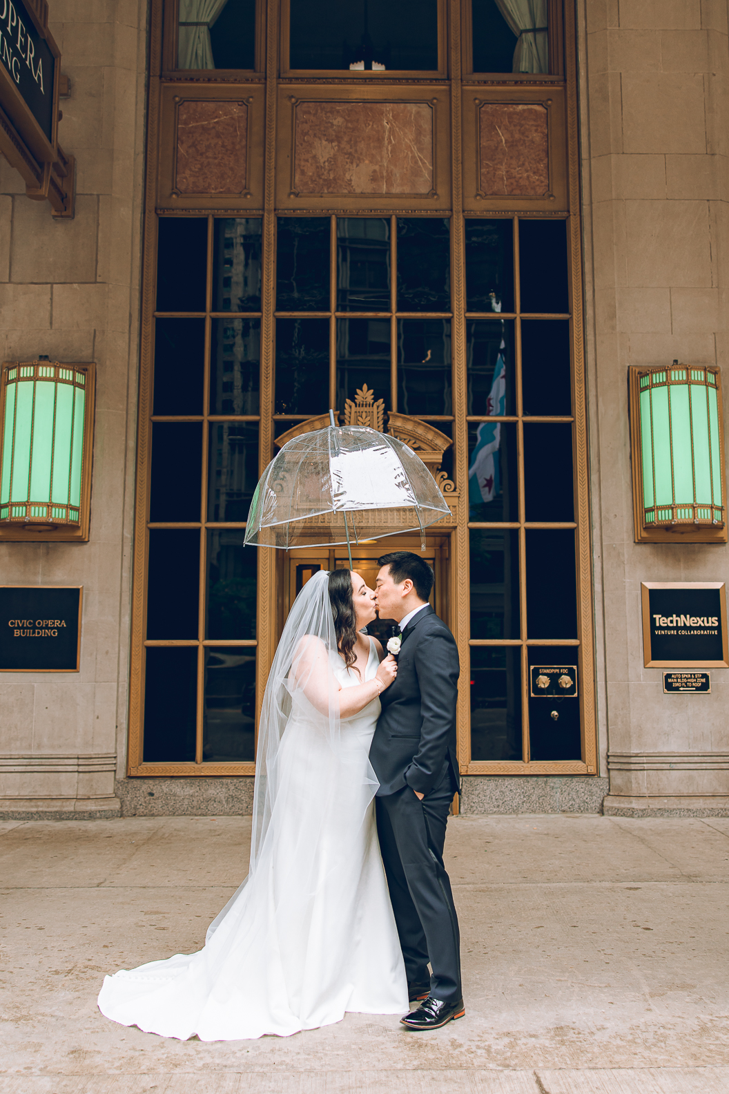 A couple poses on their wedding day under the Civic Opera Building in the Loop in Chicago.